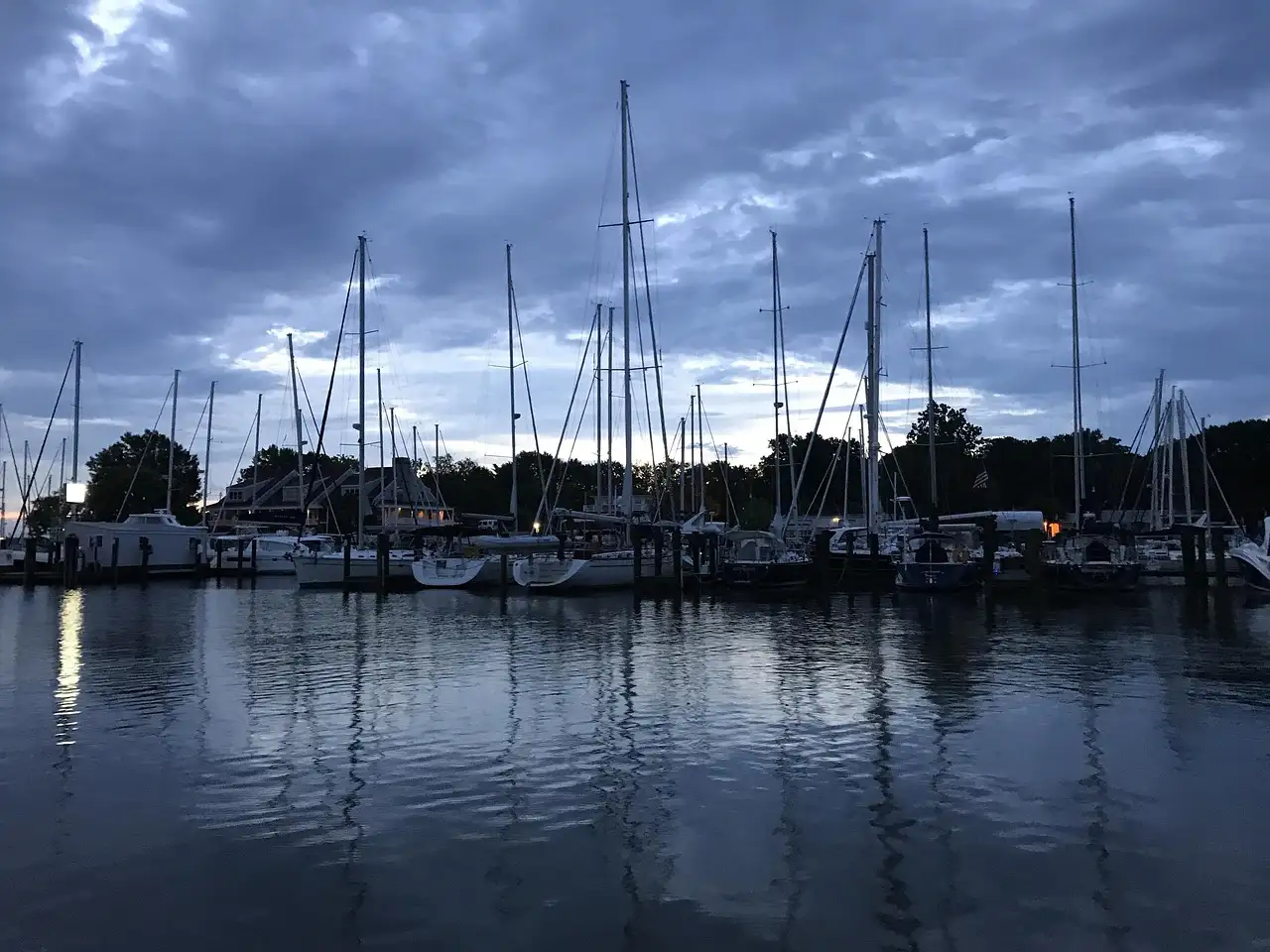 Sailboats moored in Annapolis harbor at dawn under a cloudy sky