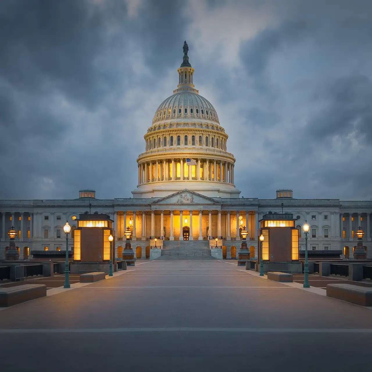 The U.S. Capitol dome lit at dusk under a cloudy sky, with an empty plaza in front