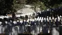 Rows of white headstones on a shaded slope at Arlington National Cemetery