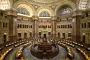 Main Reading Room of the Library of Congress with circular wooden desks under arched windows