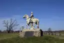 A bronze statue of a Civil War officer on horseback on the Gettysburg battlefield