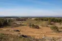 A wide view over fields, woods and boulders from Little Round Top on the Gettysburg battlefield