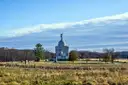 The Pennsylvania State Memorial on the Gettysburg battlefield, seen across a field with a rail fence