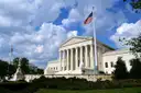 The white marble Supreme Court Building with a US flag in front