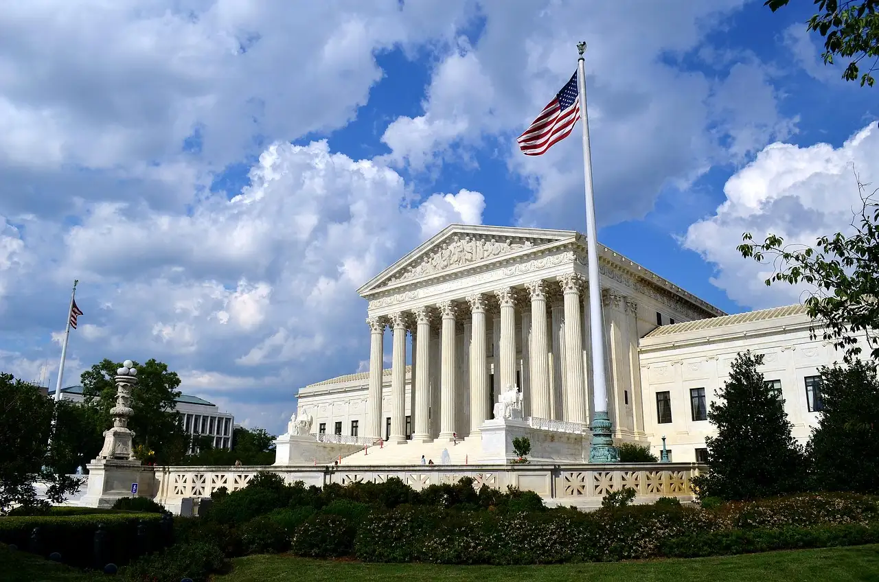 The white marble Supreme Court Building with a US flag in front