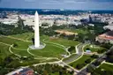The Washington Monument seen from the air, with the green National Mall and the city around it