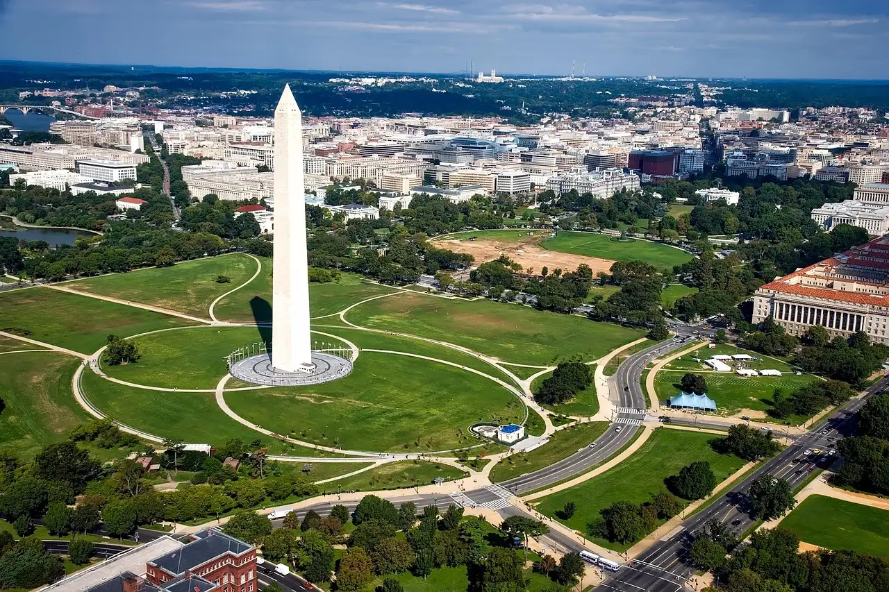 The Washington Monument seen from the air, with the green National Mall and the city around it