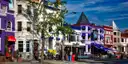 A row of brightly painted shops and houses along a street in Adams Morgan, Washington, DC.