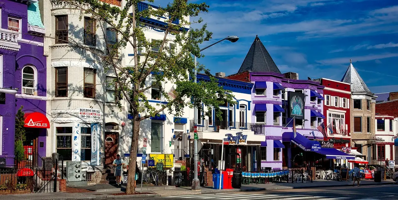 A row of brightly painted shops and houses along a street in Adams Morgan, Washington, DC.