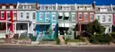 A row of colorful painted row houses on a street in Washington, DC