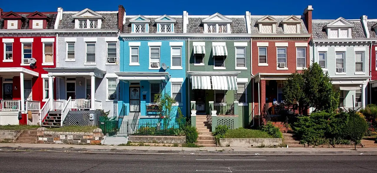 A row of colorful painted row houses on a street in Washington, DC