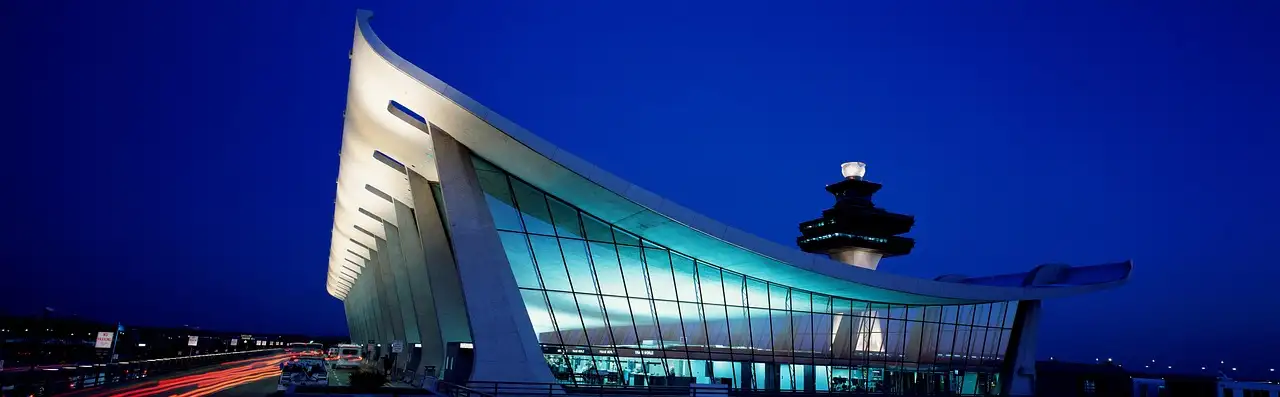 The curved roof and control tower of the Dulles Airport terminal at night