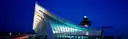 The curved roof and control tower of the Dulles Airport terminal at night