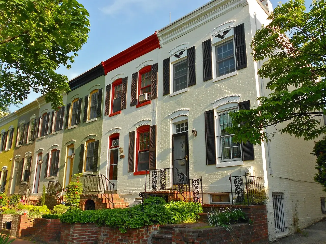Painted brick row houses with shutters and small front gardens in Foggy Bottom, Washington, DC
