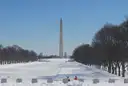The Washington Monument at the far end of a snow-covered National Mall.