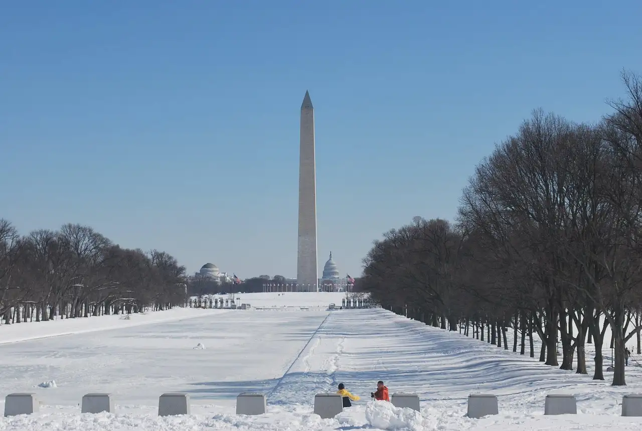 The Washington Monument at the far end of a snow-covered National Mall.