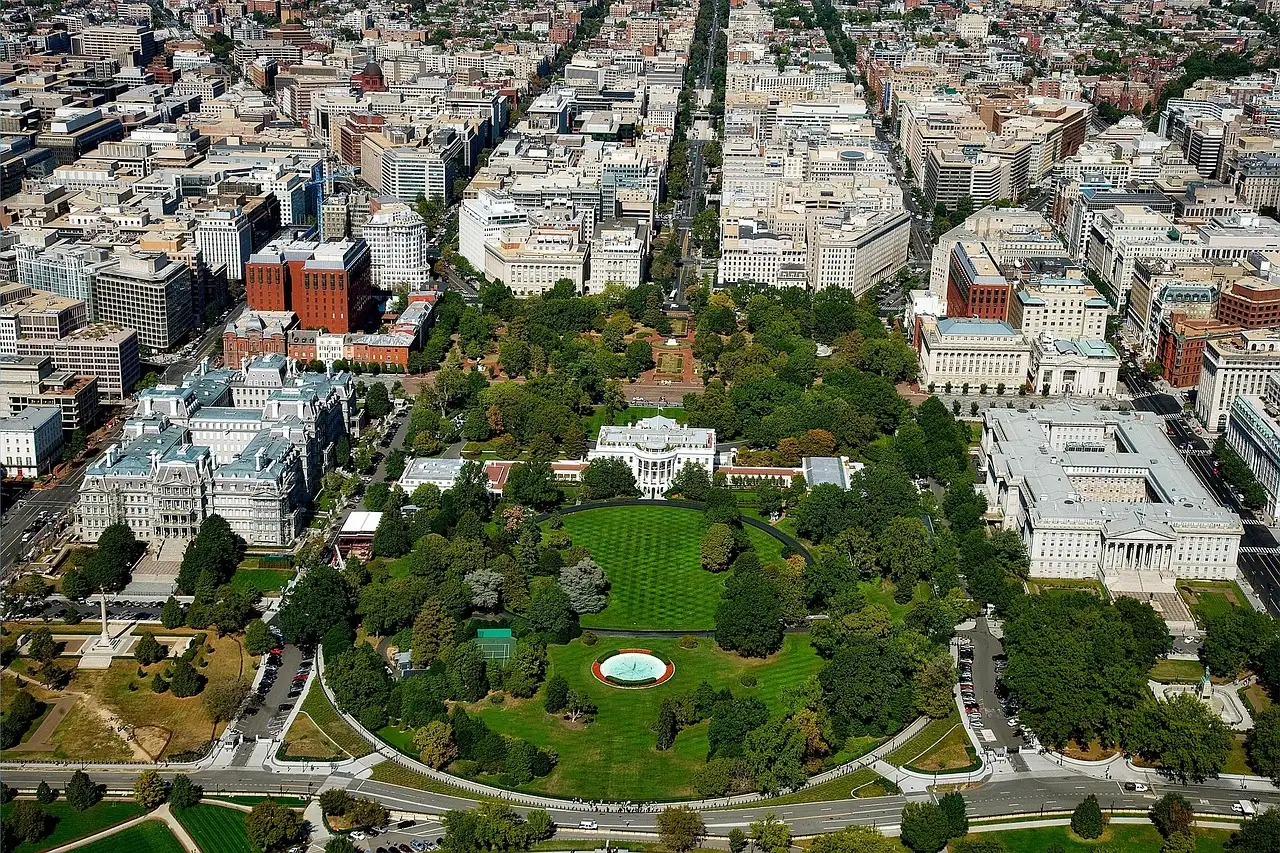 Aerial view of the White House and its lawns among downtown Washington, DC streets