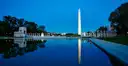 The World War II Memorial and the Washington Monument reflected in still water at dusk