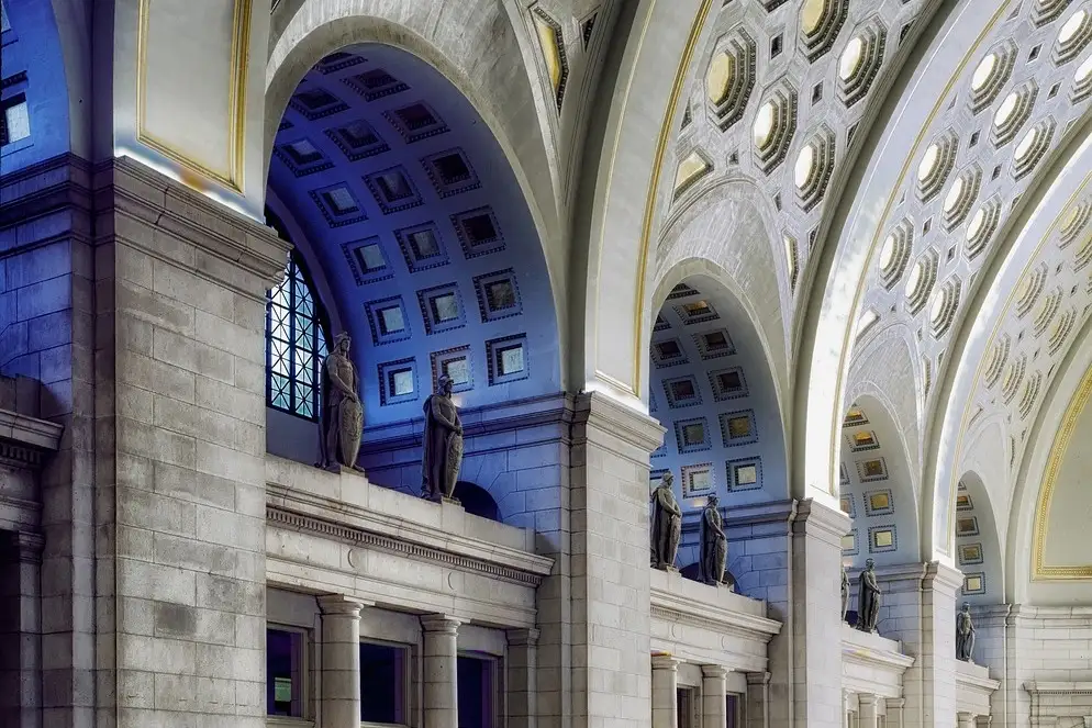 Tall coffered arches and statues above the doors of the main hall of Union Station in Washington, DC.