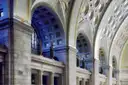 Tall coffered arches and statues above the doors of the main hall of Union Station in Washington, DC.
