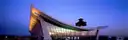 The curved roof and control tower of Dulles International Airport's main terminal at dusk.