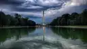 The Washington Monument across the Reflecting Pool under heavy storm clouds.